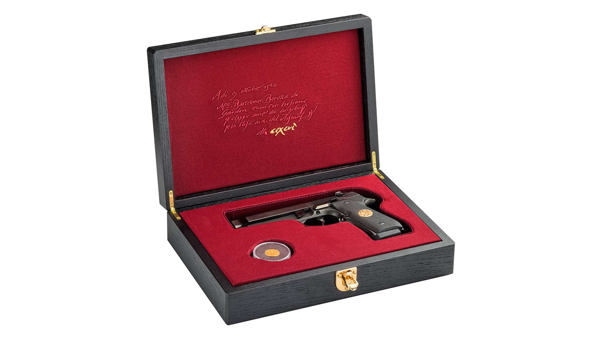 Open black wood presentation case with red lining holding a Beretta 92FS Ducato pistol, a capsuled gold ducat and an embroidered 1526 manuscript