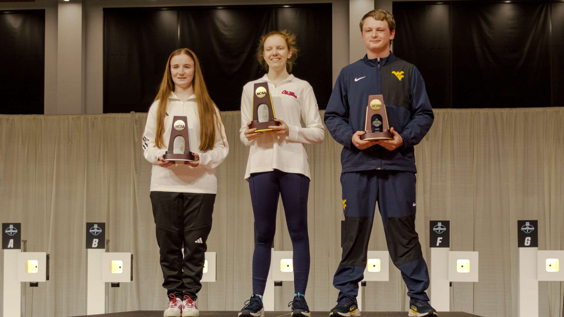 Katyln Sullivan, Audrey Gogniat and Griffin Lake on 2026 NCAA air rifle championship podium at Ohio State's Covelli Center