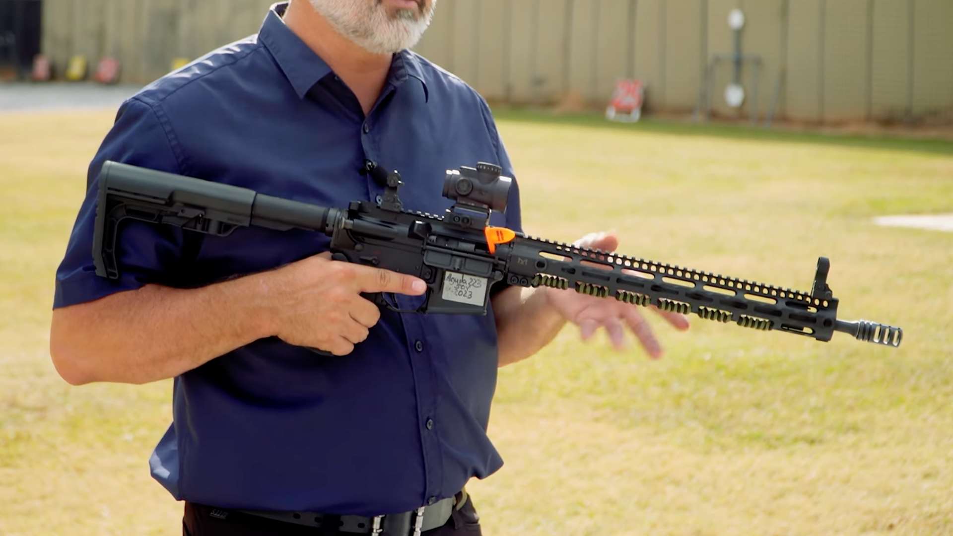 Ryan Muller holding an AR-15 configured for NRA America’s Rifle Challenge Stock division with non-magnified red-dot sight during ARC divisions instructional video