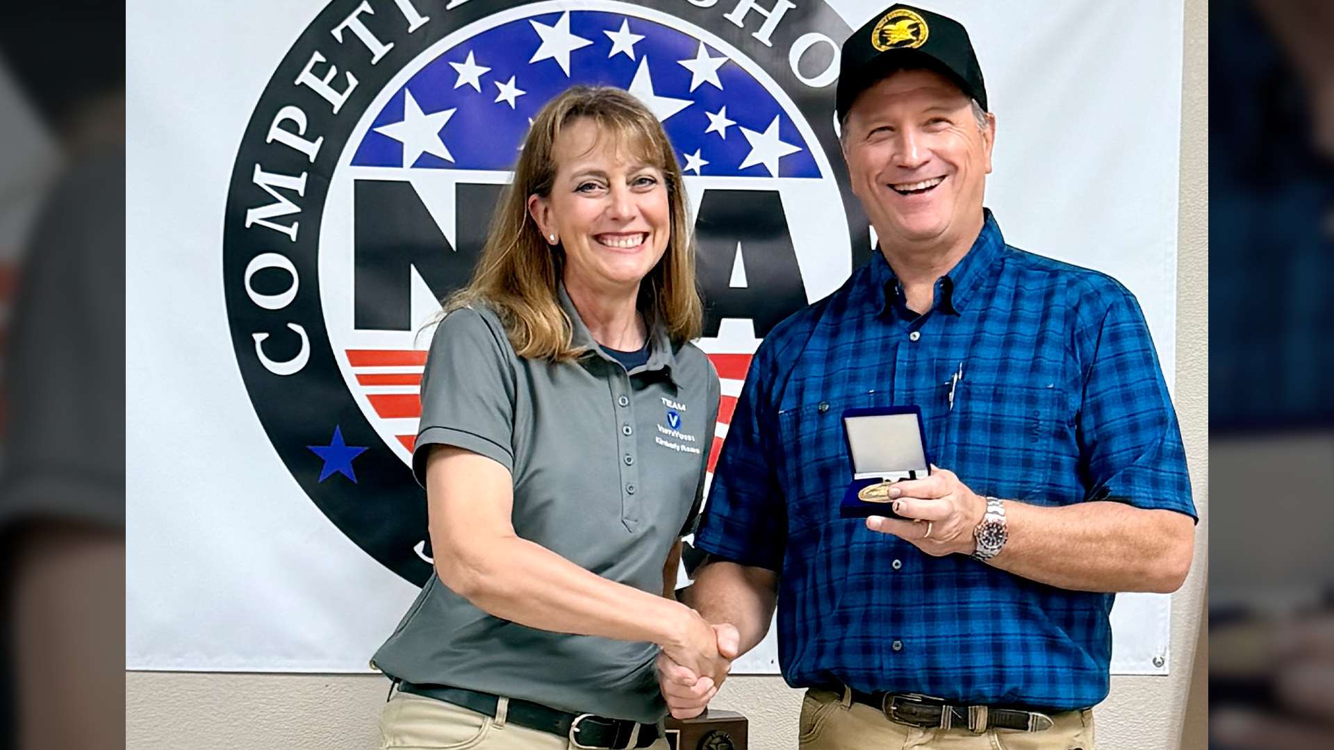 NRA First Vice President Mark Vaughan shaking hands with Mid-Range champion Kim Rowe during the Patriot Minuteman Trophy presentation