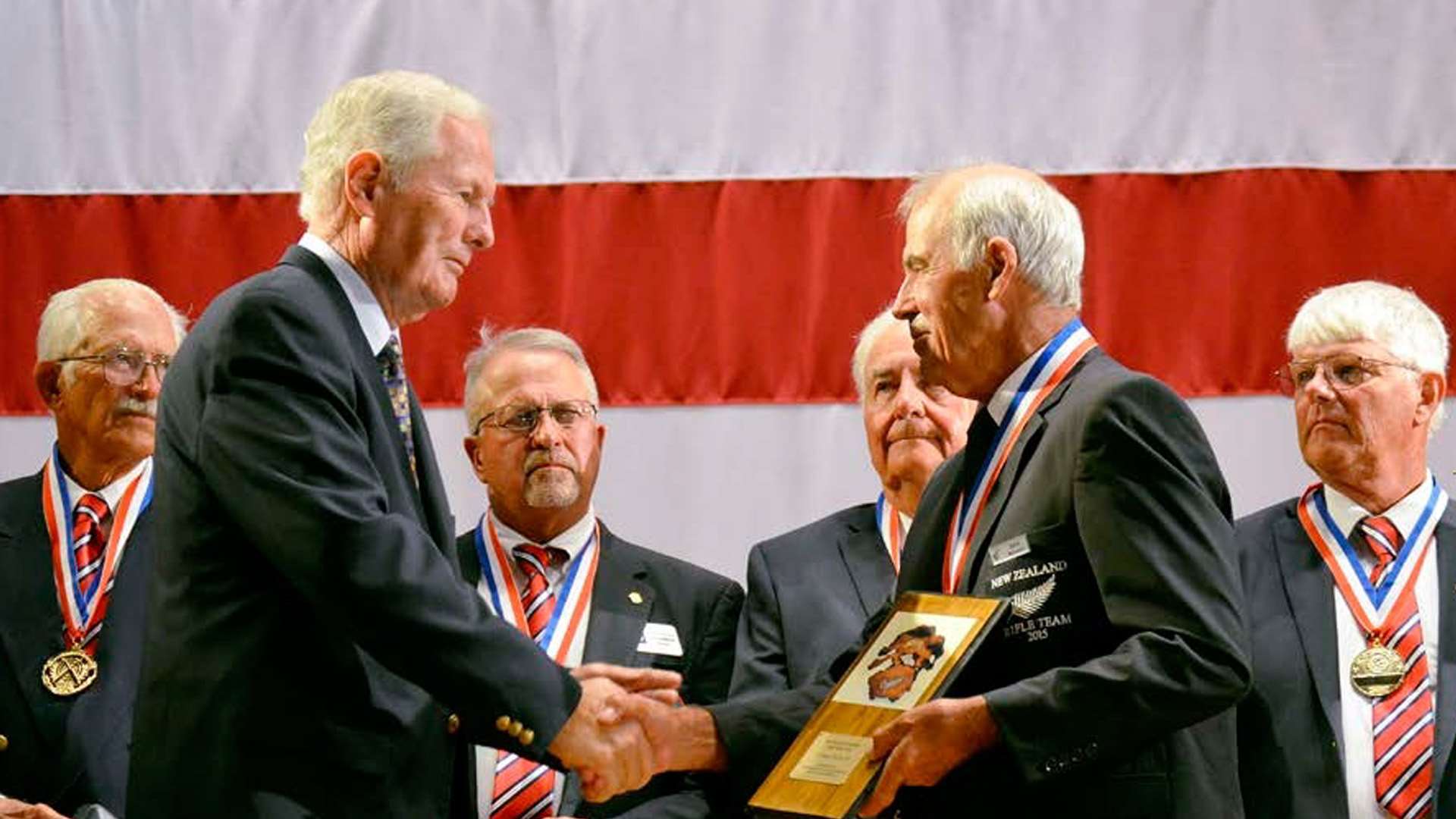 Allan Cors shaking hands with New Zealand Rifle Team coach John McLaren at a Camp Perry awards ceremony