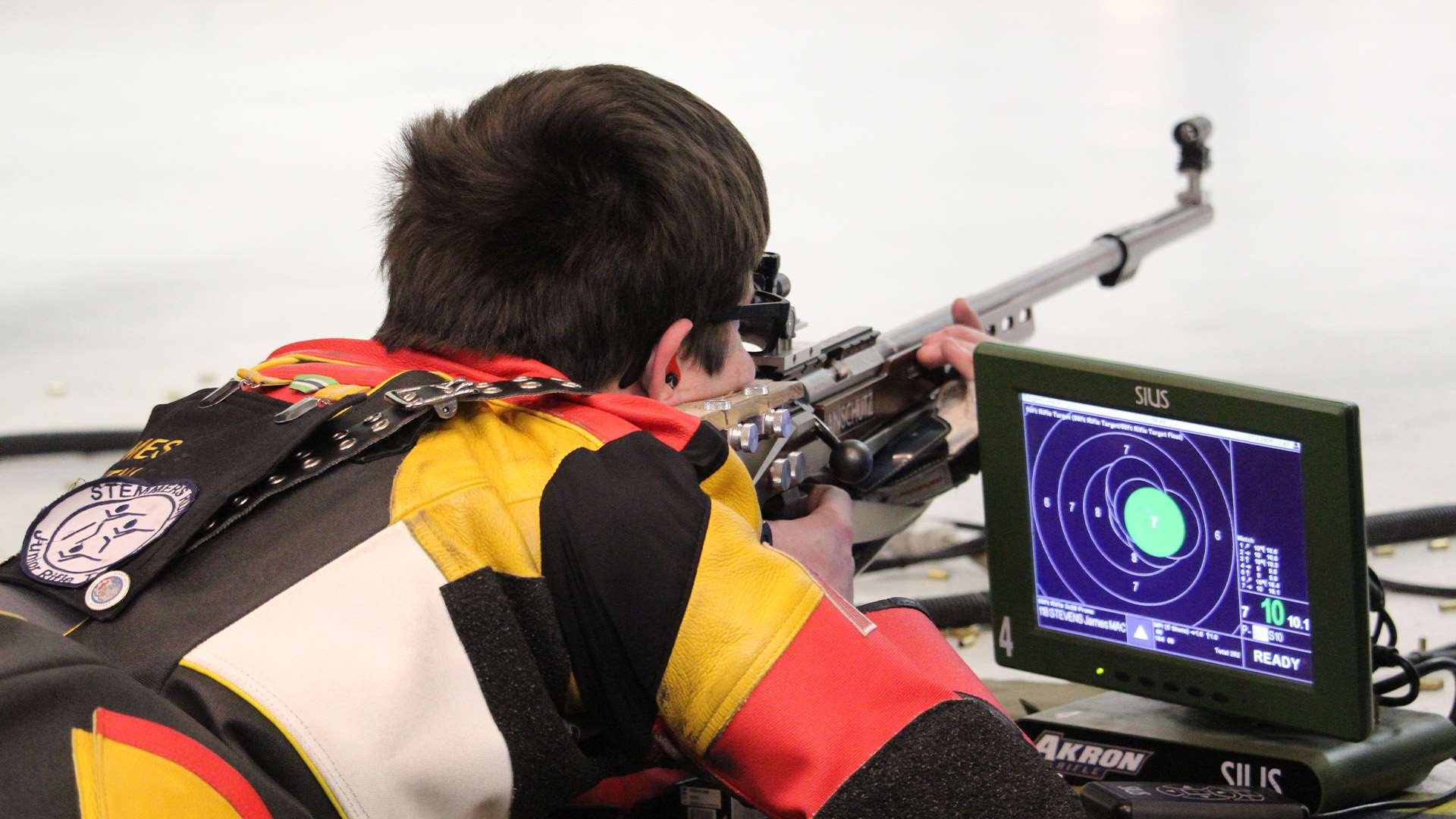 Mount Aloysius College rifle shooter James Stevens in the prone position with an Anschütz smallbore rifle and SIUS electronic scoring monitor