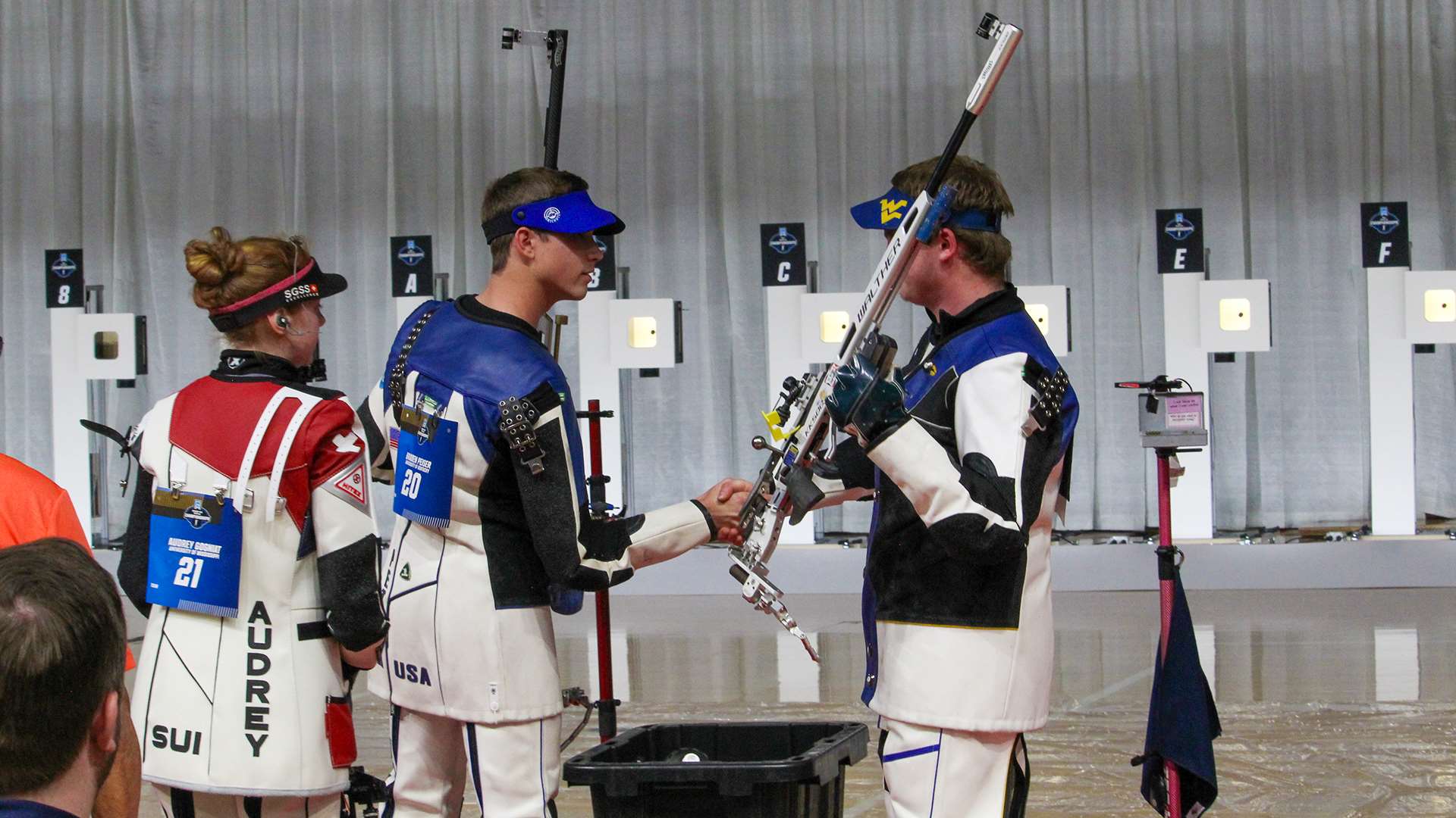 Braden Peiser and Griffin Lake shake hands while Audrey Gogniat looks on