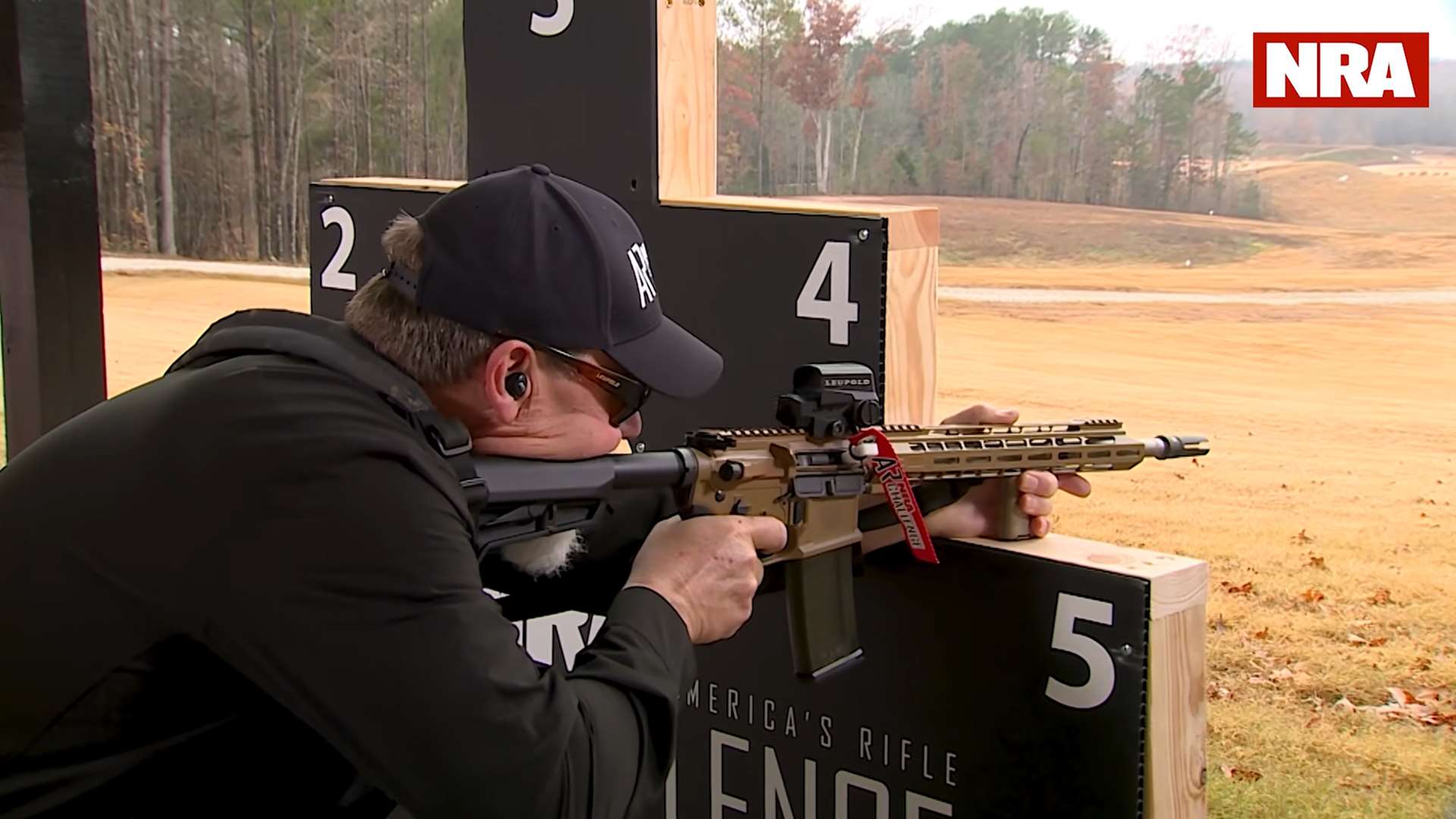 Kyle Lamb with AR-15 on the NRA America’s Rifle Challenge barricade during instructional video on the practical benefits of competition