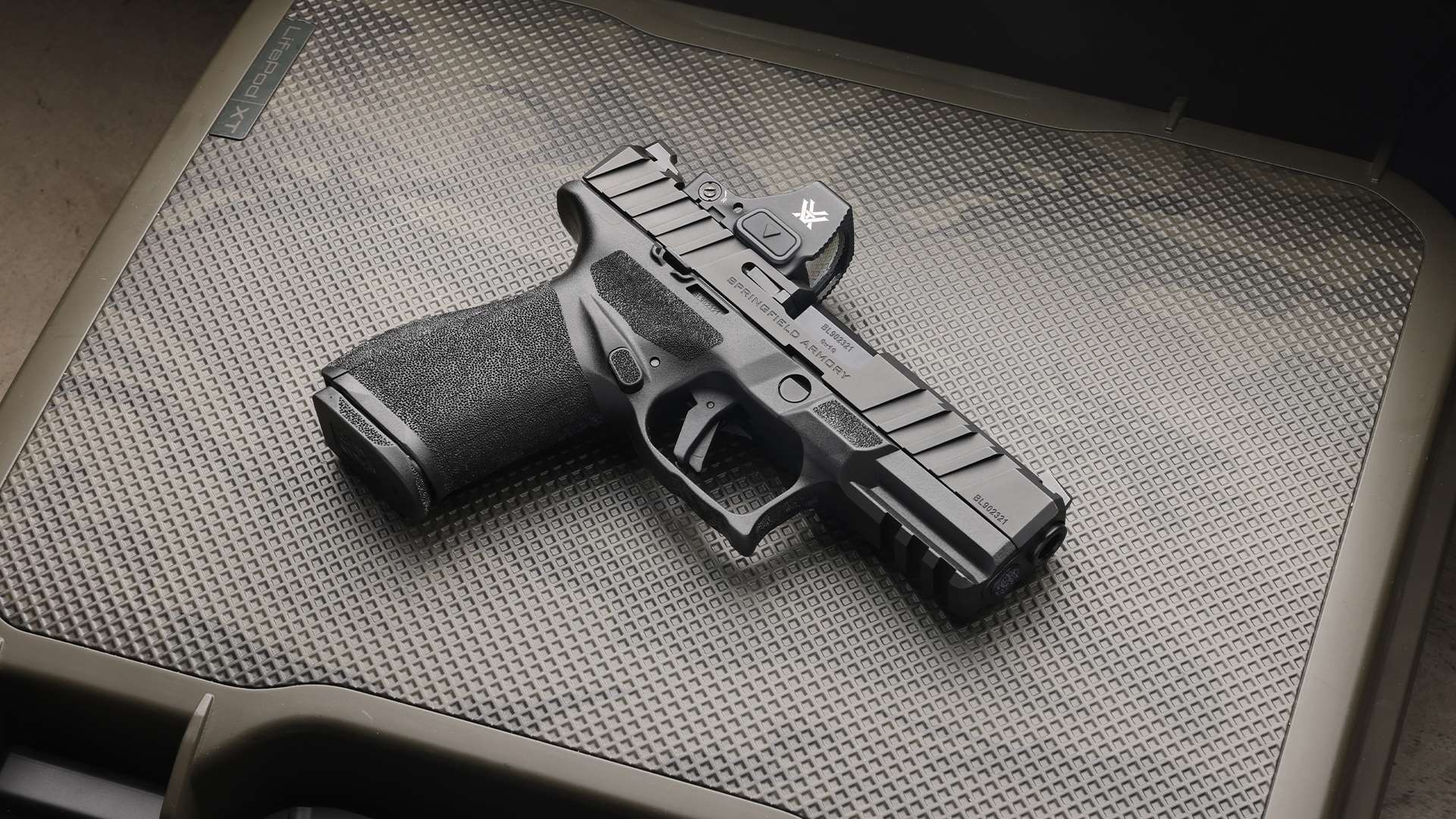 Springfield Armory Echelon Alpha 4.0C 9 mm pistol fitted with a Vortex Defender red dot sight, photographed on a textured pistol case insert