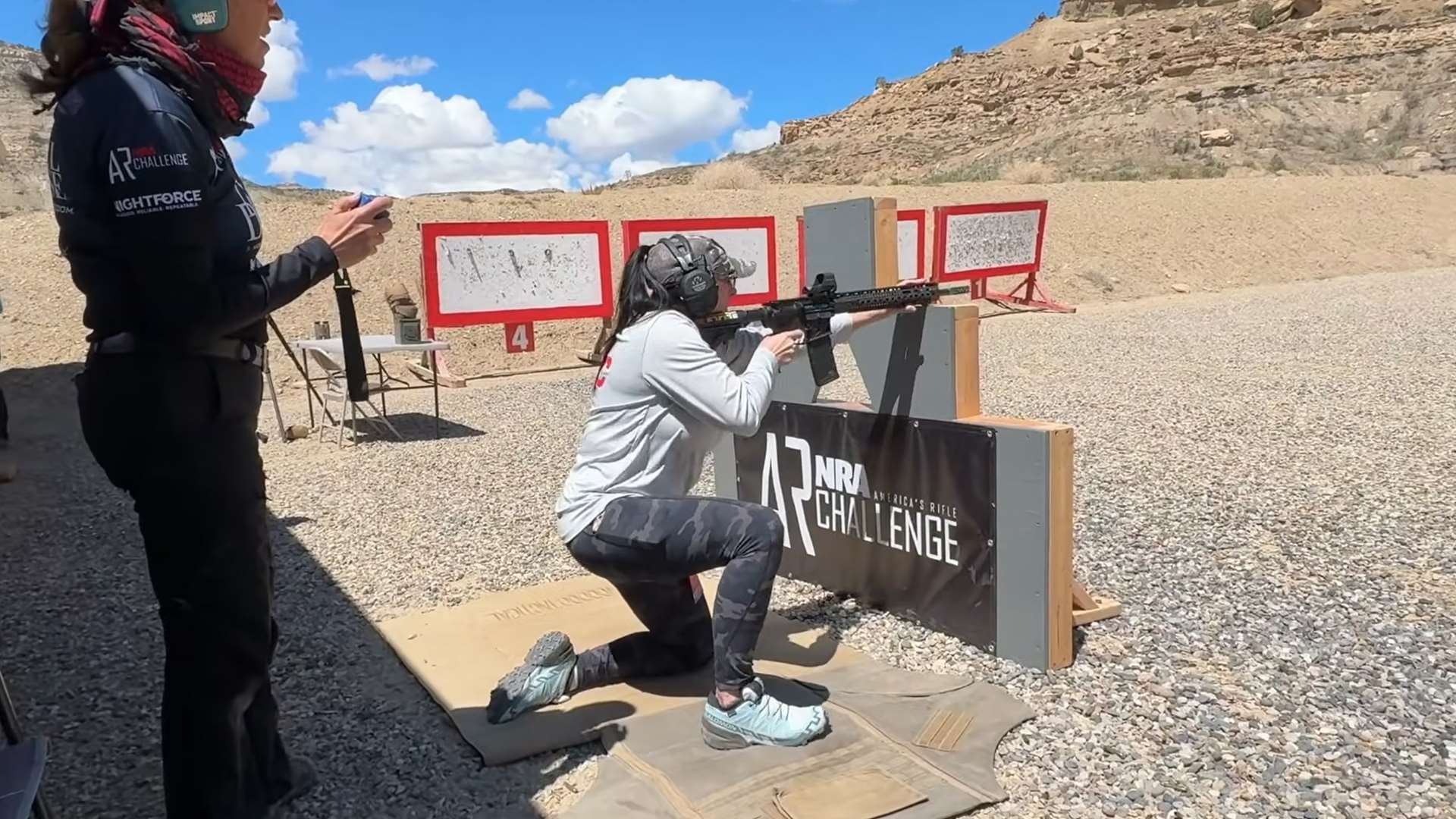 Woman shooting AR-15 from kneeling position at NRA America’s Rifle Challenge barricade during A Girl and A Gun National Conference at Cameo Shooting Complex in Grand Junction Colorado