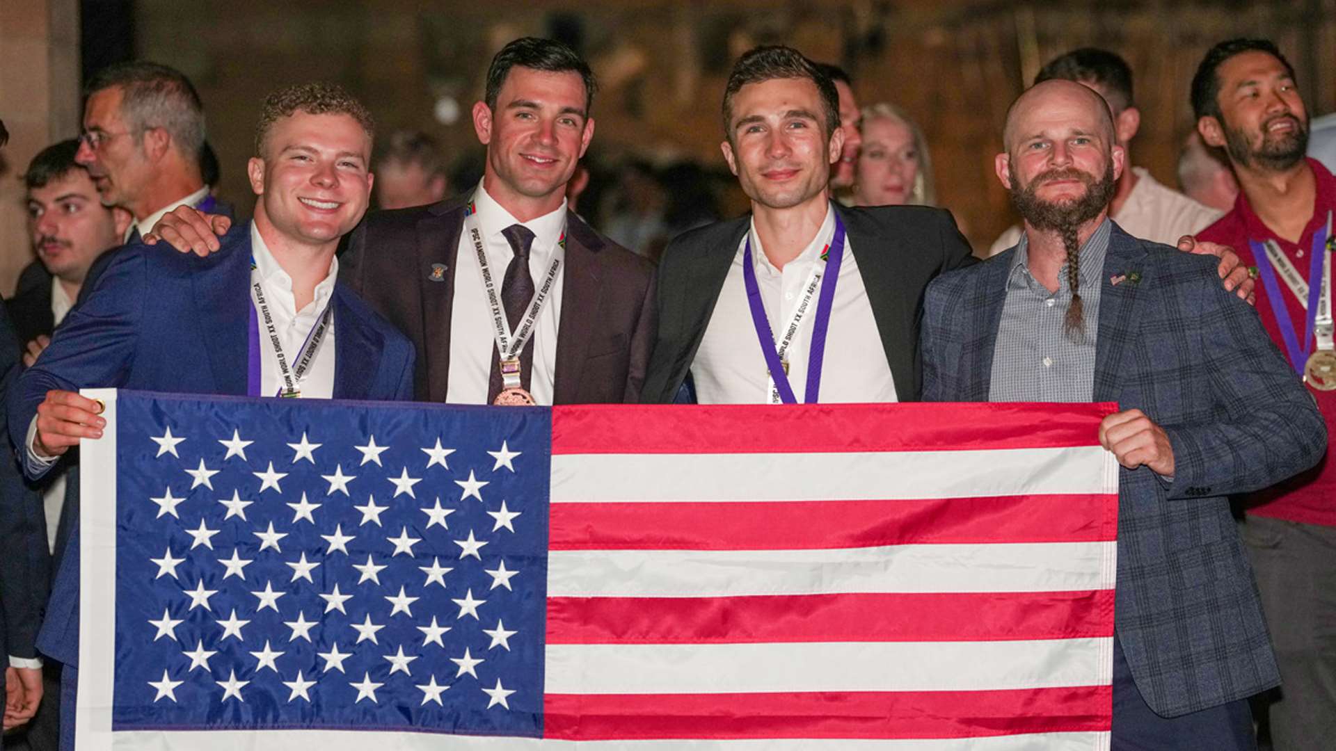 Christian Sailer and teammates celebrate with medals and the American flag at the 2025 IPSC Handgun World Shoot in South Africa