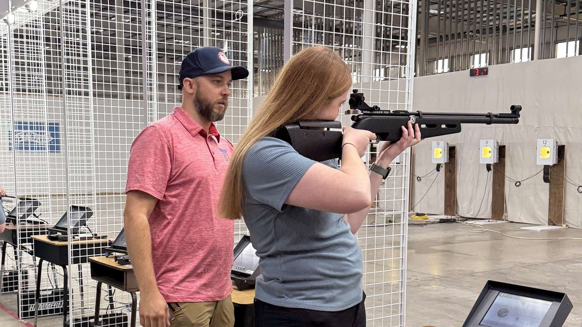 Youth shooter with rifle is being coached at MidwayUSA Foundation event