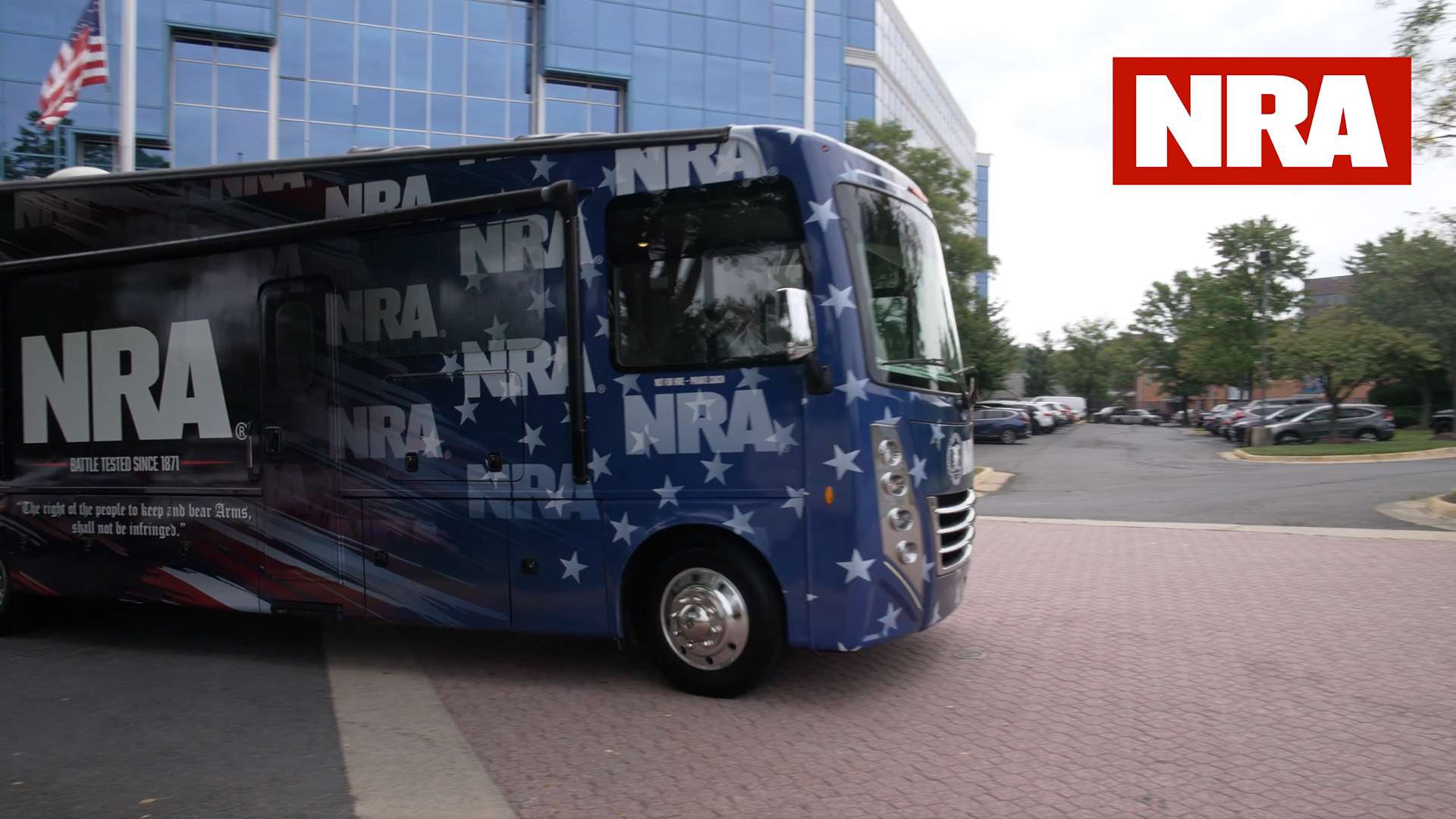 Front quarter view of the star-spangled NRA Gun Bus pulling forward on a brick drive outside NRA headquarters in Fairfax, Va.