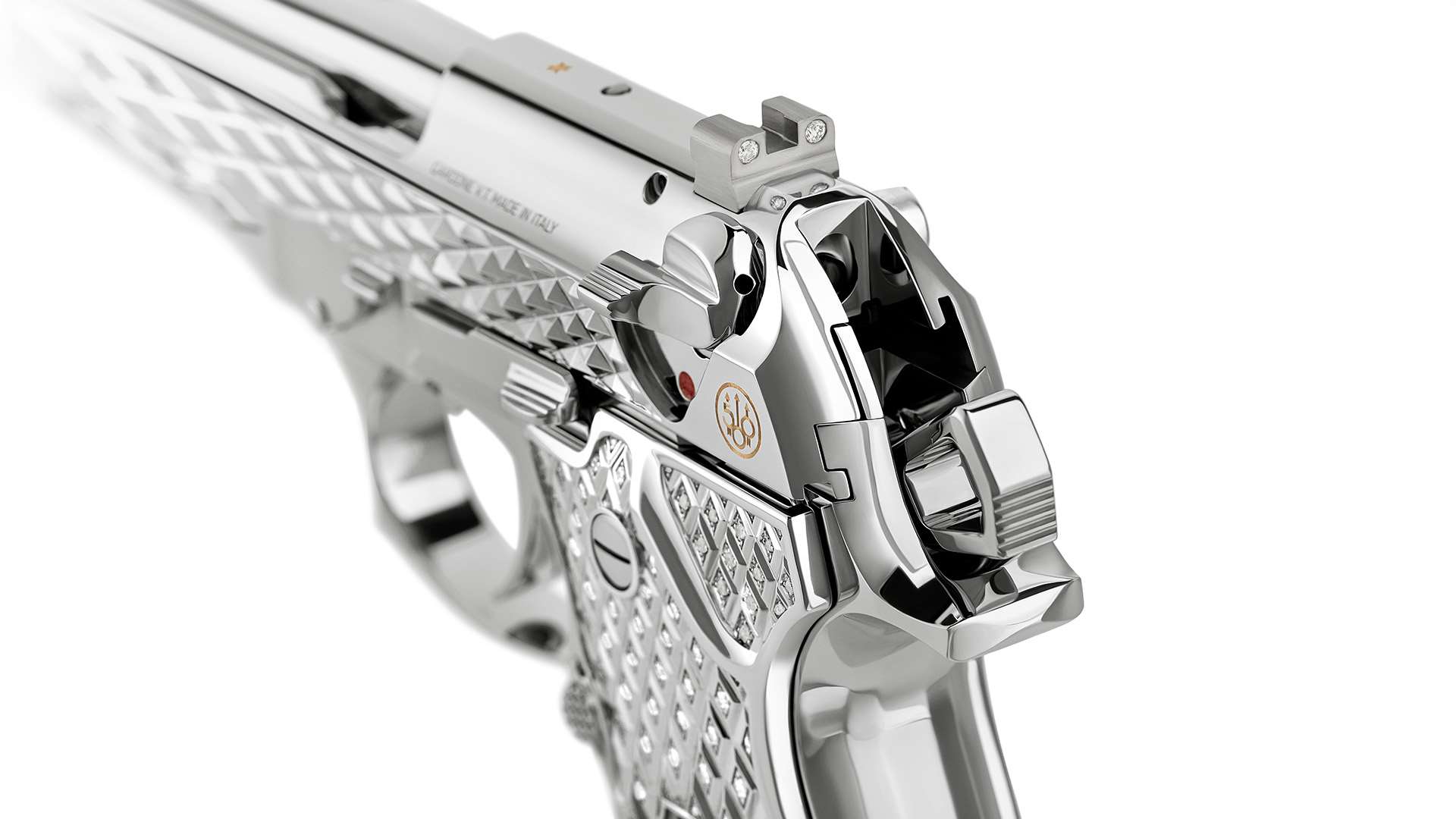 Rear three-quarter close-up of the Beretta 92FS Diamond showing diamond-set rear sight, gold 500th anniversary logo and pyramid slide serrations