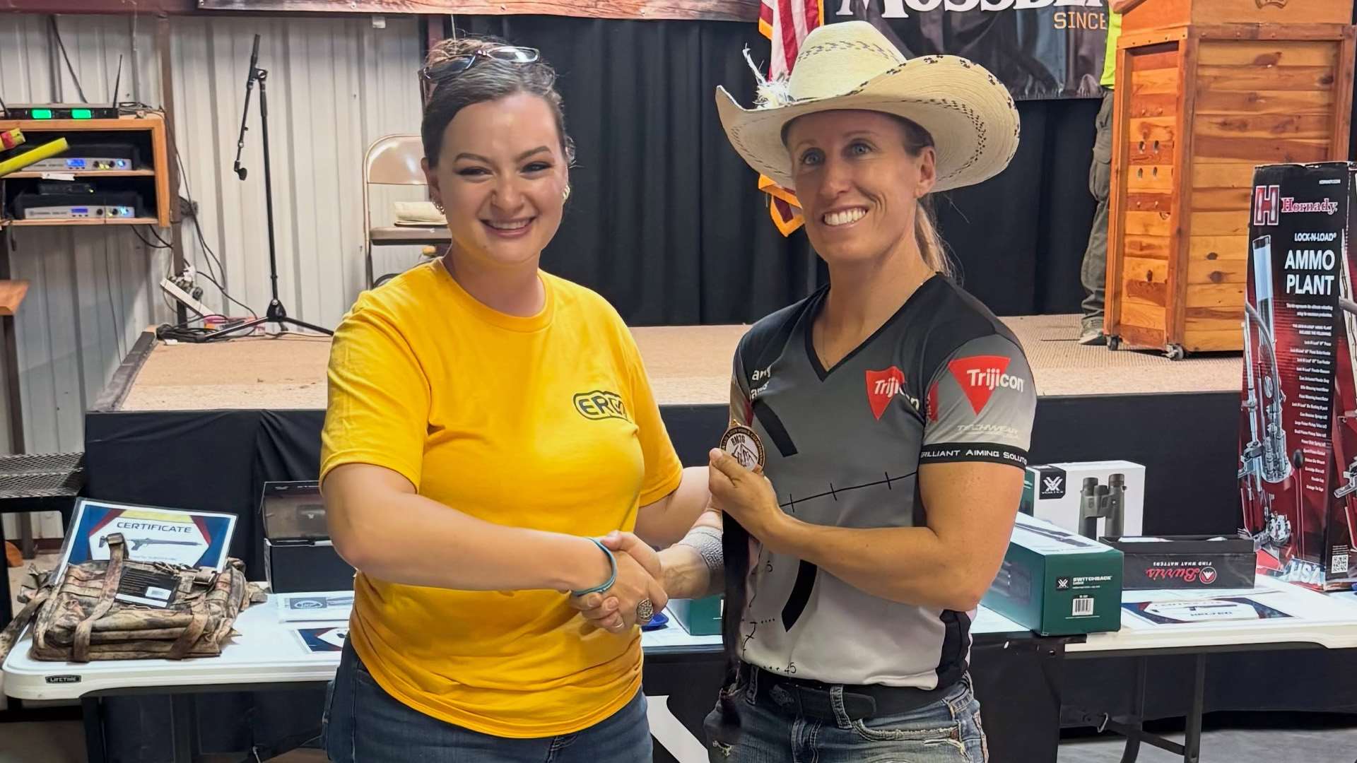 Lanny Barnes in a straw hat shaking hands and receiving an award medallion at a match awards ceremony
