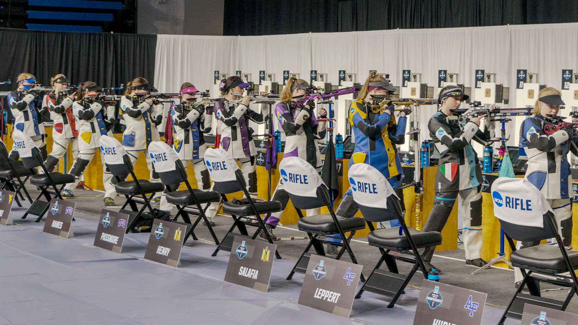Collegiate air rifle competitors in standing position at the 2025 NCAA Rifle Championship
