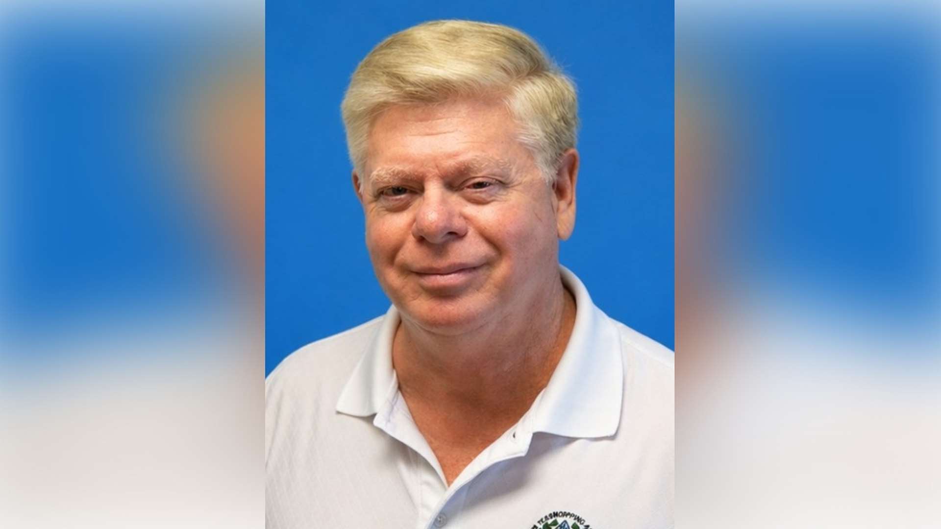 Headshot of Lynn Gipson wearing a white ATA polo shirt against a blue background