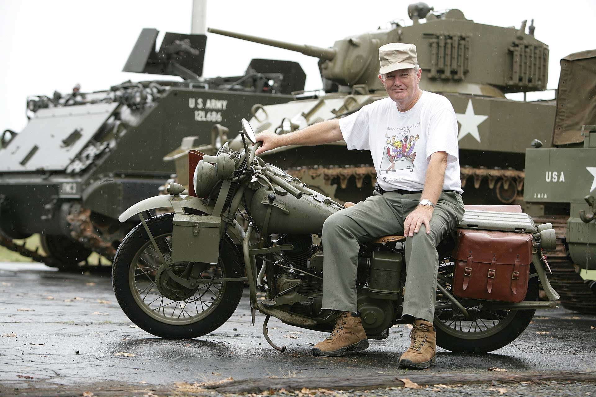 Allan D. Cors sitting on a motorcycle at his tank farm