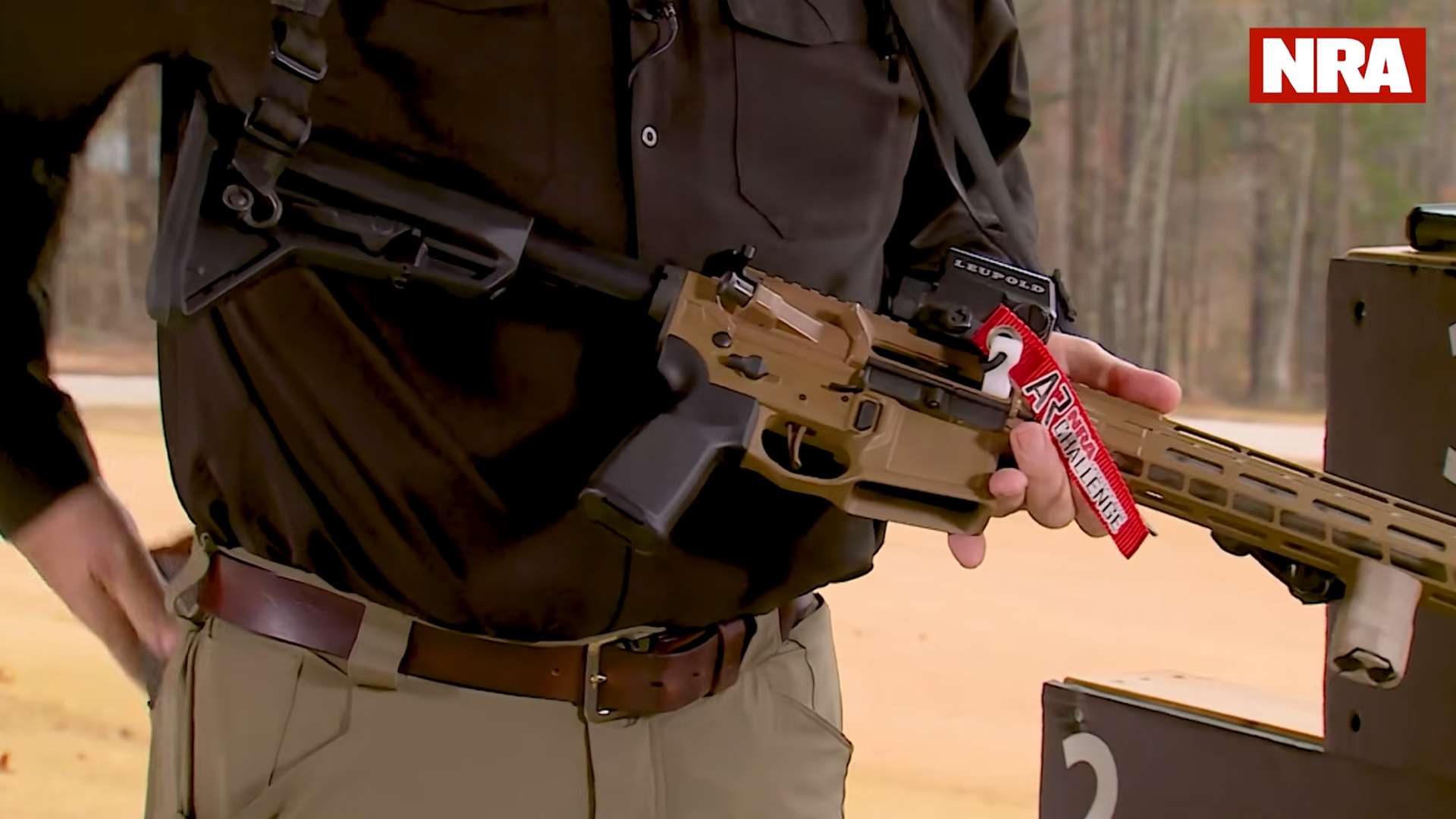 Kyle Lamb inserting empty chamber indicator into AR-15 ejection port during NRA America’s Rifle Challenge safety demonstration in practical benefits of competition video