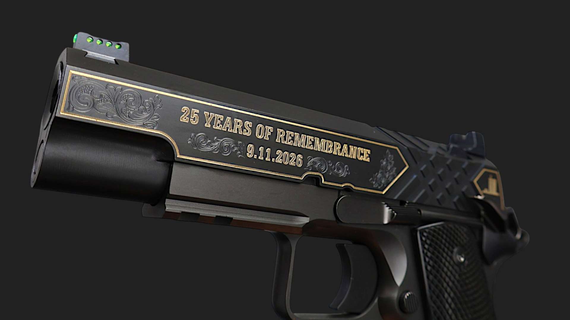 Close-up of the left side of a black SK Guns 1911 Commander pistol, gold engraving reading "25 Years of Remembrance 9.11.2026" with scrollwork, green fiber-optic front sight and a Picatinny rail beneath the bull barrel