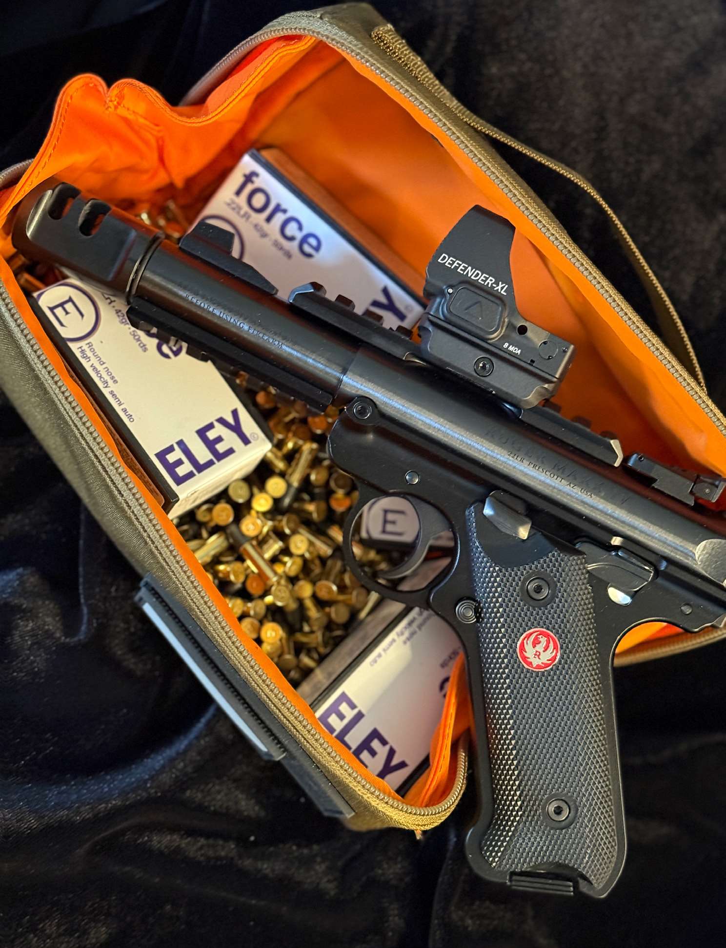 Ruger Mark IV Tactical pistol resting in an orange-lined range bag with Vortex Defender-XL red dot, Tandemkross compensator, and ELEY force .22 LR ammunition boxes