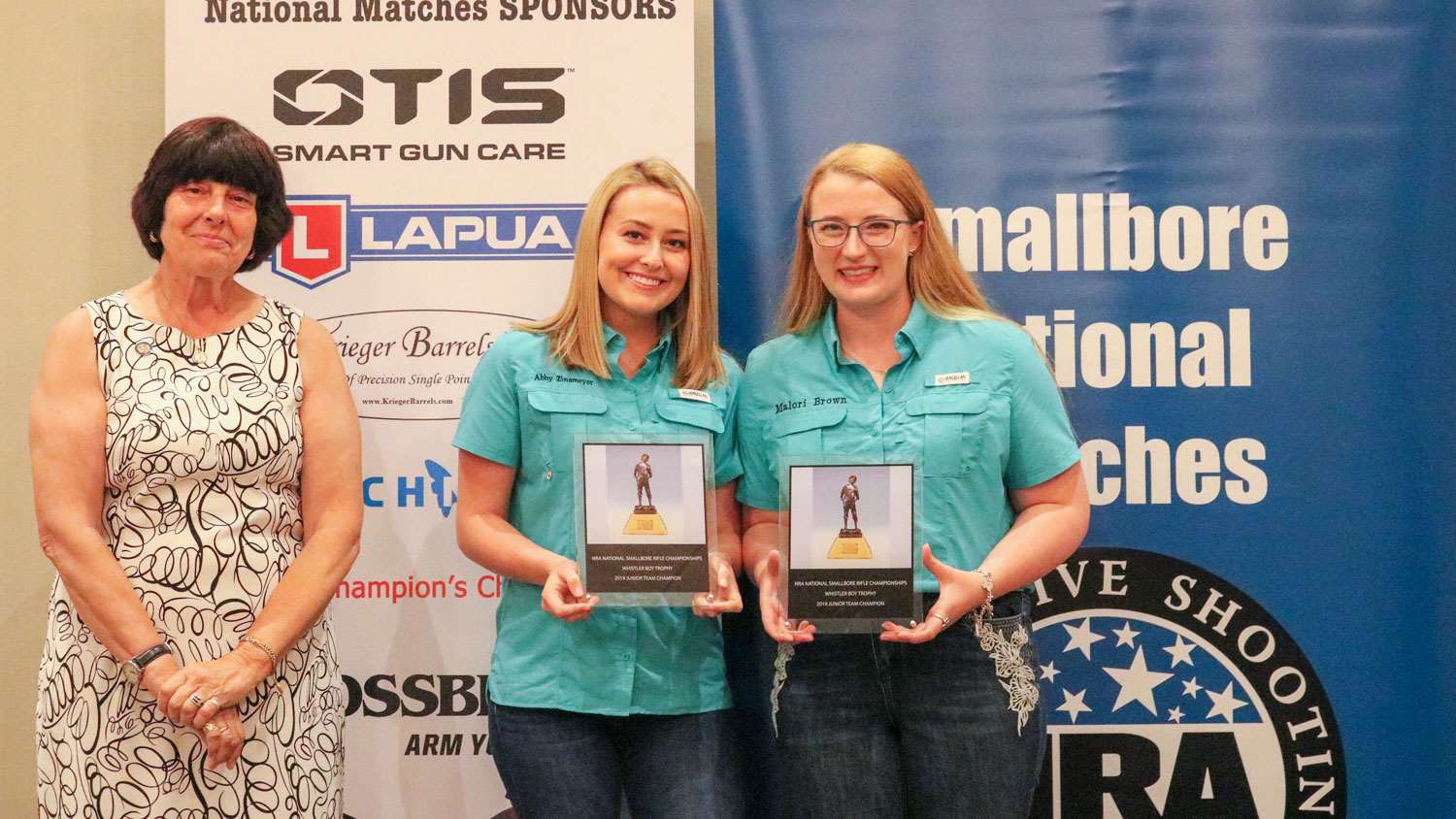 NRA Board Member Patty Clark presents Brown and Zinsmeyer with trophy plaques for their 2019 Whistler Boy team victory.