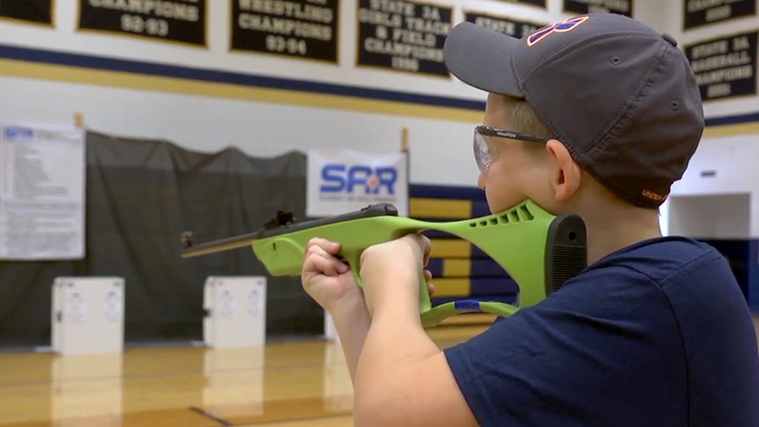 Student air rifle program competitor practicing in a Missouri h.s. gymnasium