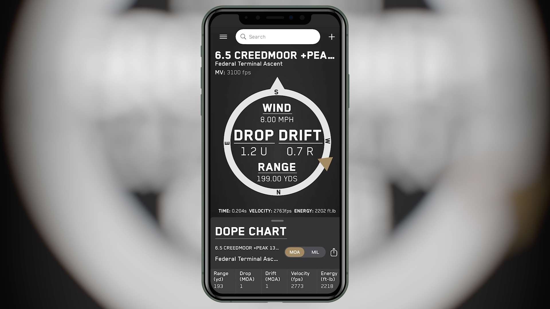 Smartphone displaying Ballistic AE's combined screen with a compass wind dial, drop and drift corrections and a DOPE chart below