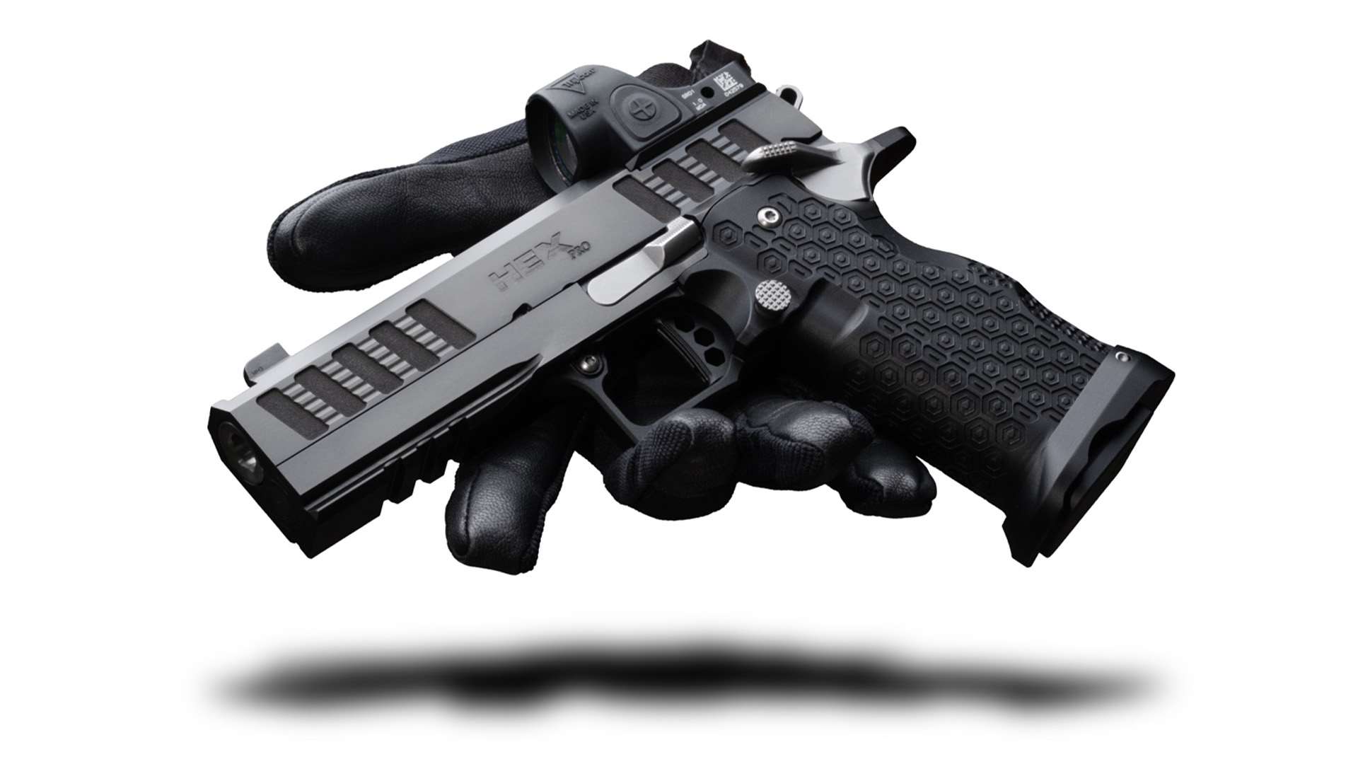 Jacob Grey Hex Pro pistol with a Trijicon red-dot optic mounted, resting on a black shooting glove against a white background