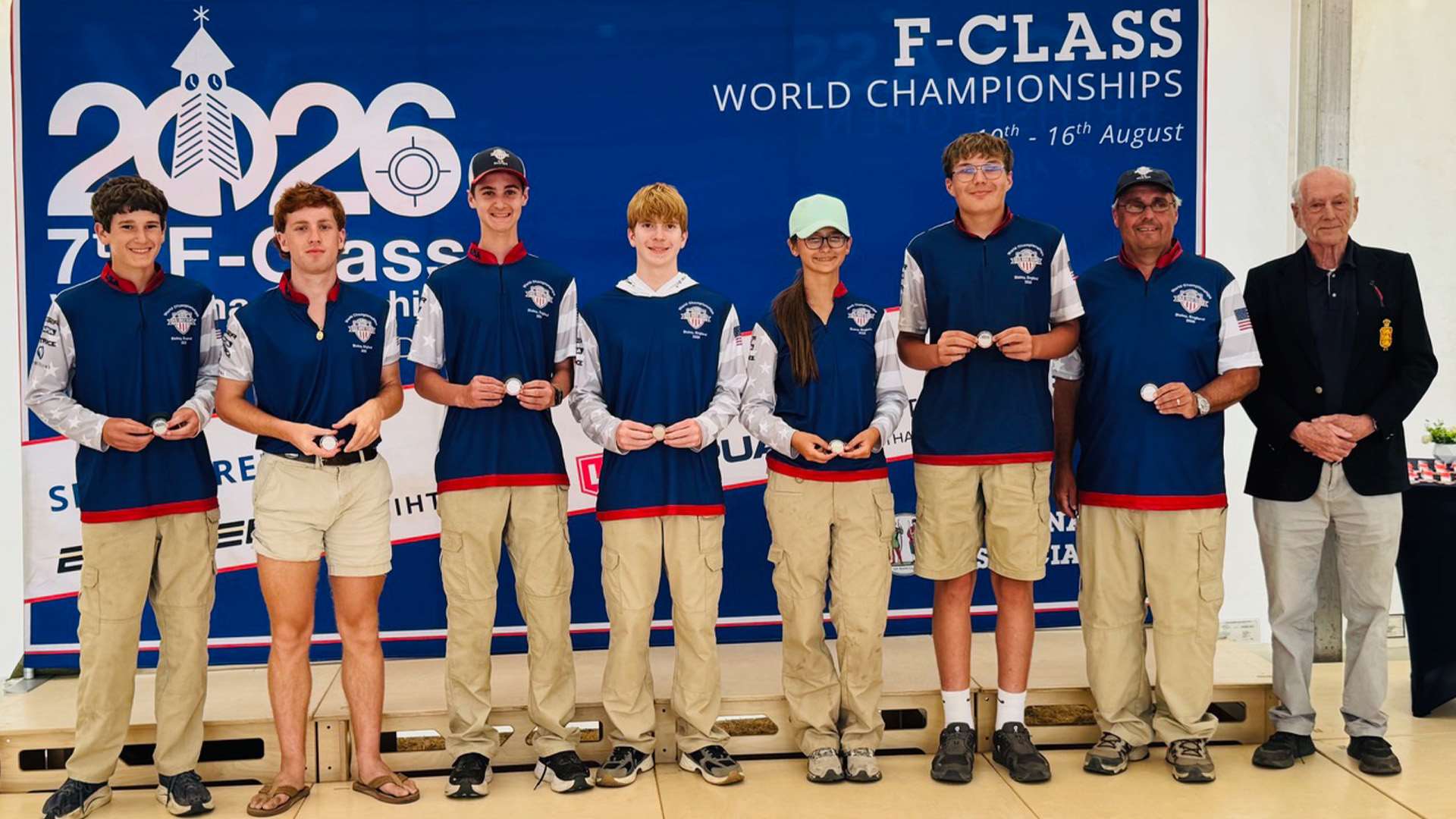 Members of the USA Under-25 F-Open Team standing in a row holding silver medals in front of a 2026 F-Class World Championships banner