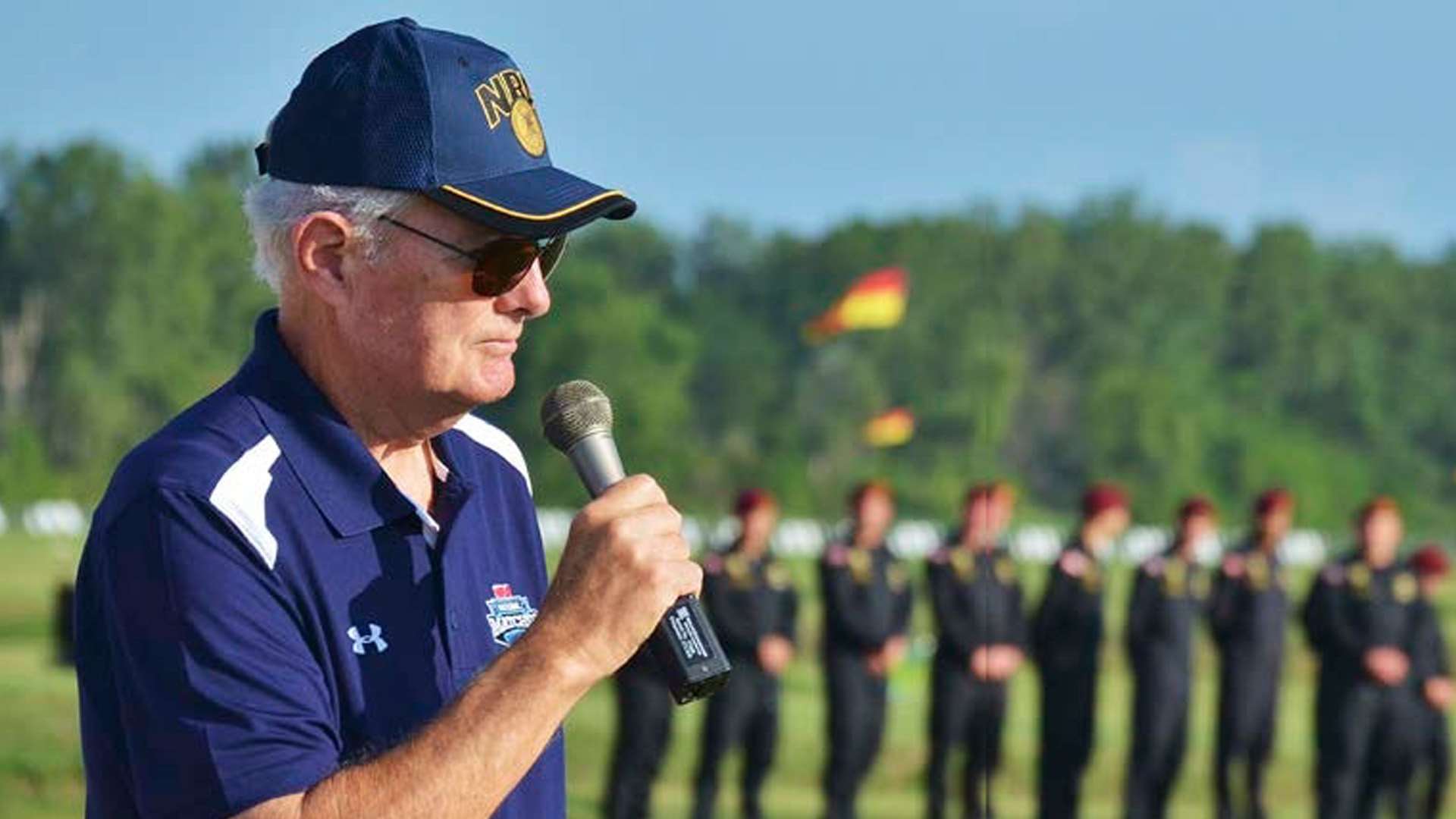 Allan Cors speaking at a podium during the 2015 World Long-Range Palma Rifle Championship opening ceremony