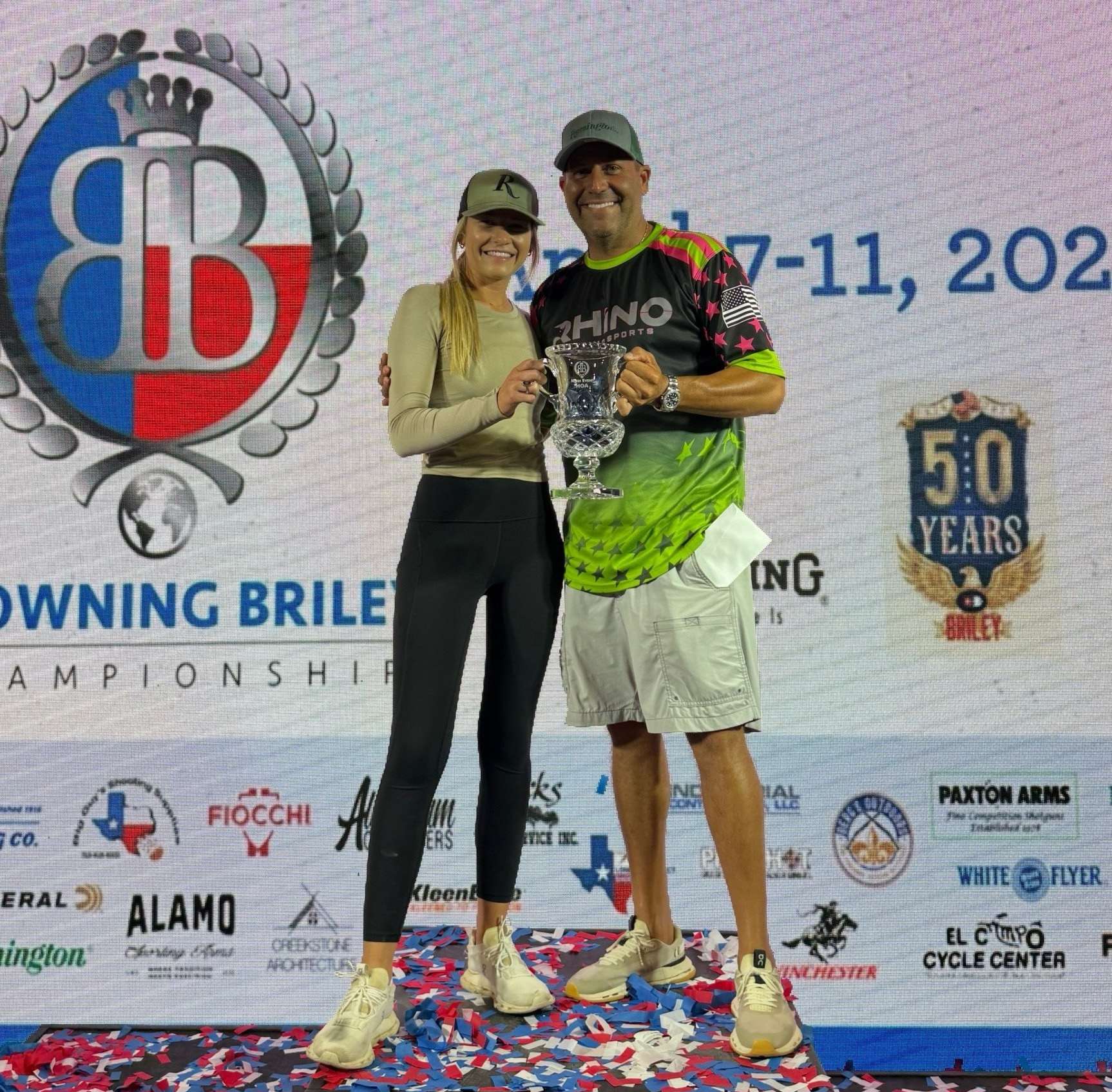 Madison Sharpe and Brandon Powell smile on stage during the awards ceremony at the 2026 Browning Briley sporting clays tournament