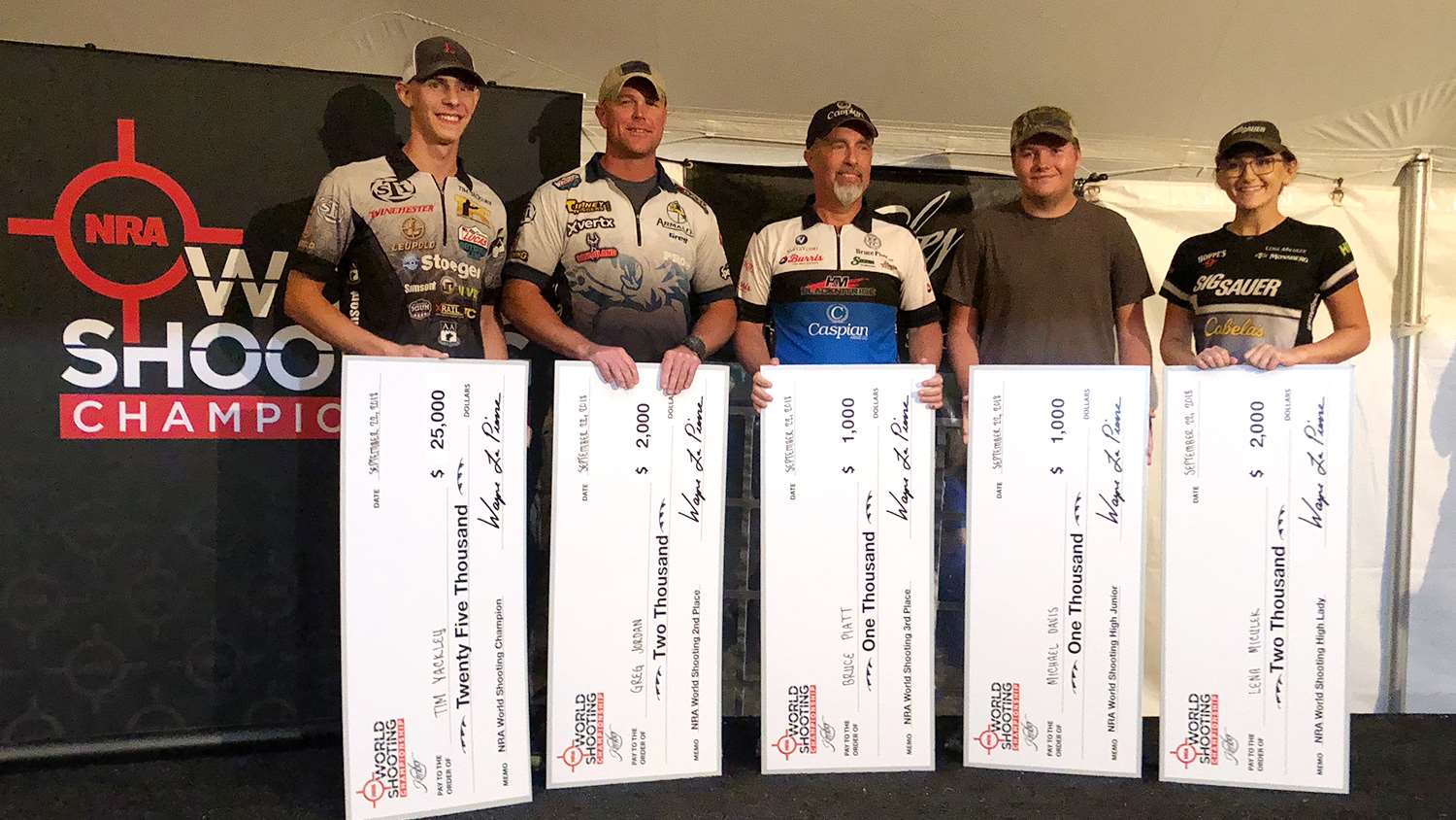 Shooters take the stage at the 2018 NRA World Shooting Championship awards ceremony: (l. to r.) Tim Yackley, Greg Jordan, Bruce Piatt, Michael Davis and Lena Miculek