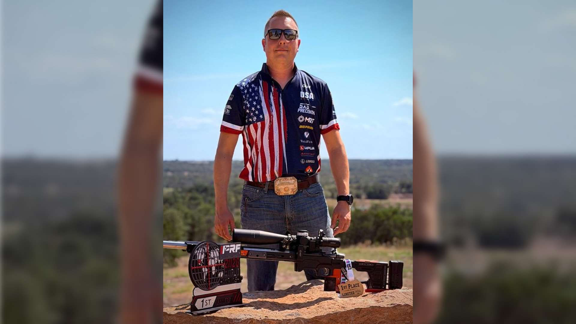 Chad Heckler stands behind a scoped precision rifle on a rock, with an IPRF 2026 World Championship trophy and a first-place medal