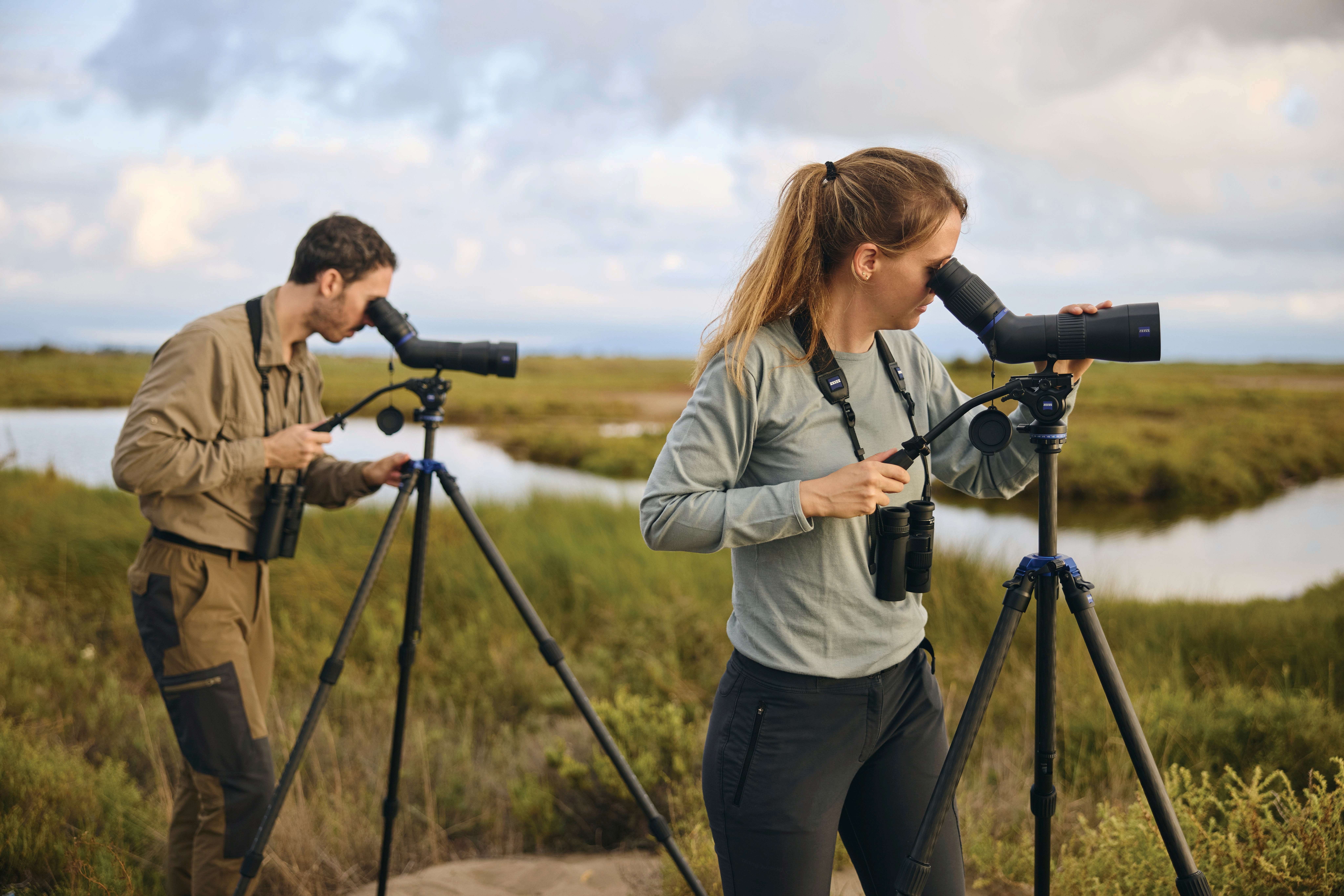 A pair of Zeiss Conquest Apia 65 spotting scopes mounted on tripods in a field