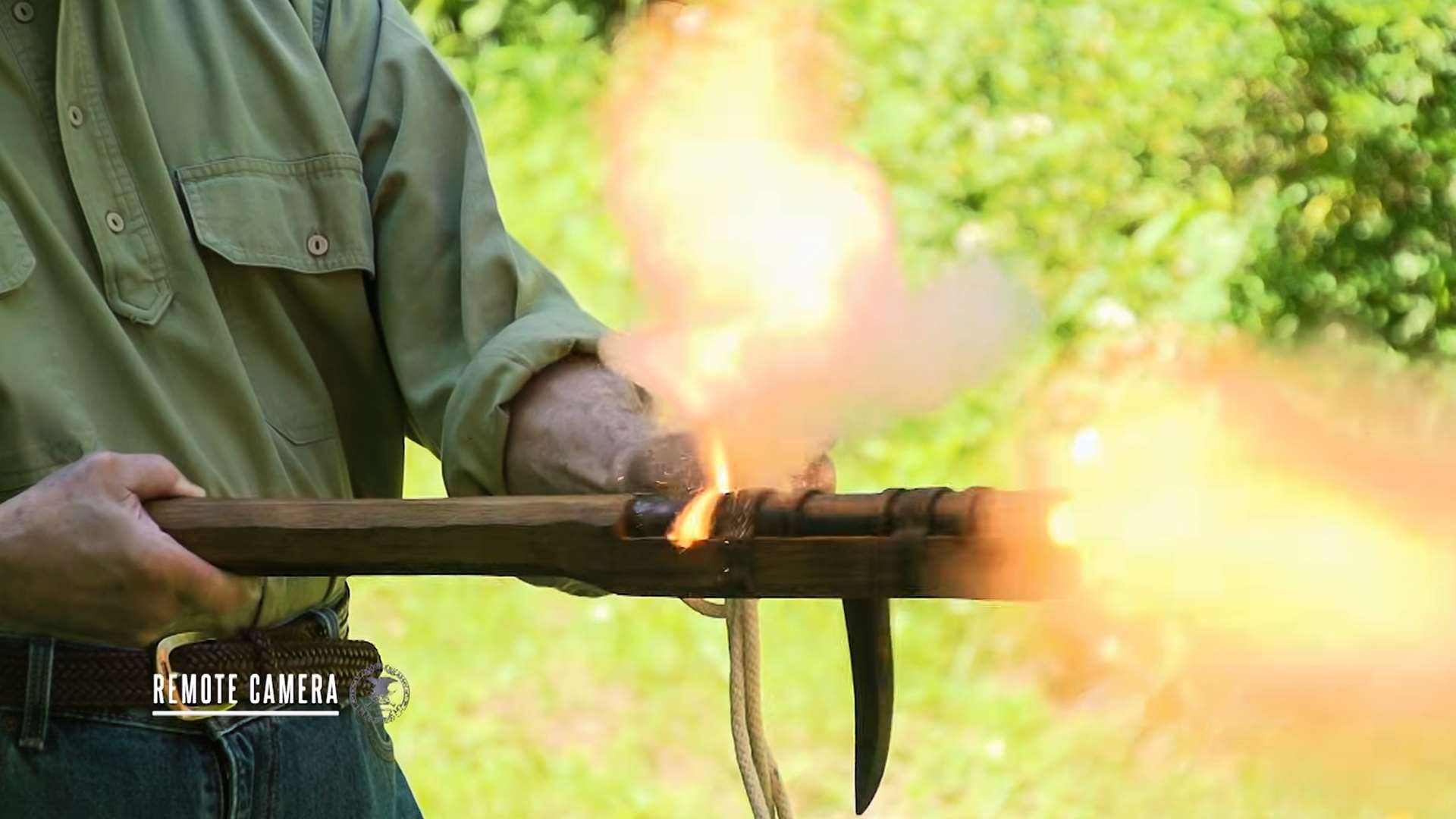 Remote camera view of a man firing a hand cannon at an outdoor range during American Rifleman TV I Have This Old Gun segment on hand cannon history