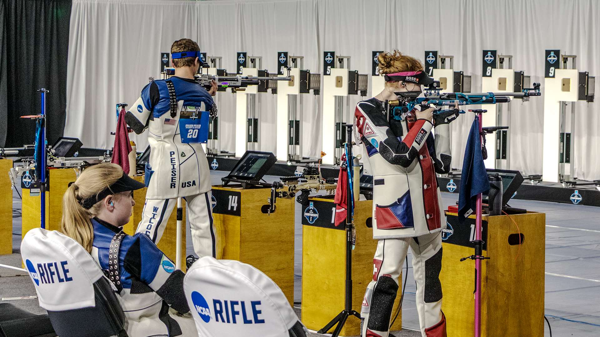 Collegiate air rifle competitors in standing position at the 2025 NCAA Rifle Championship