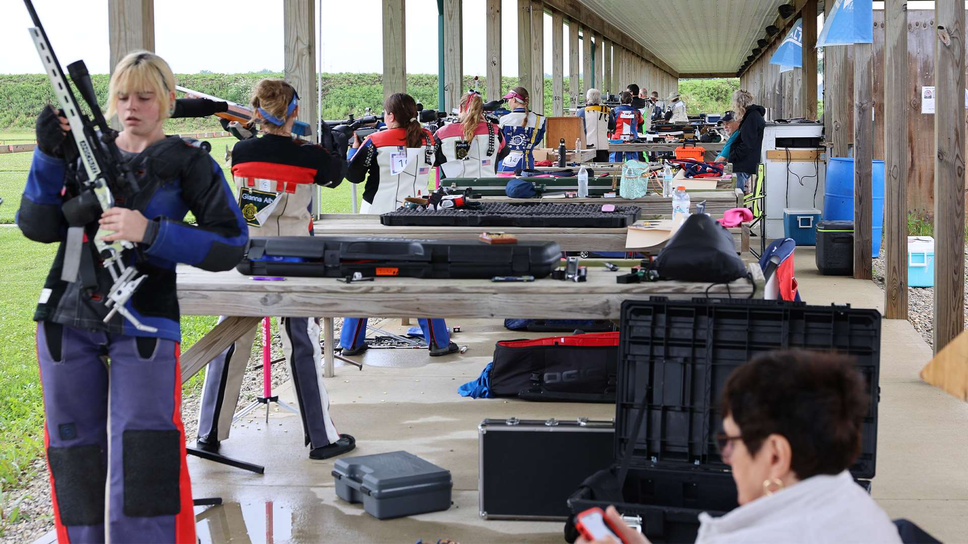 Smallbore three-position competitors on the firing line, with Victoria Cornett shooting in the foreground