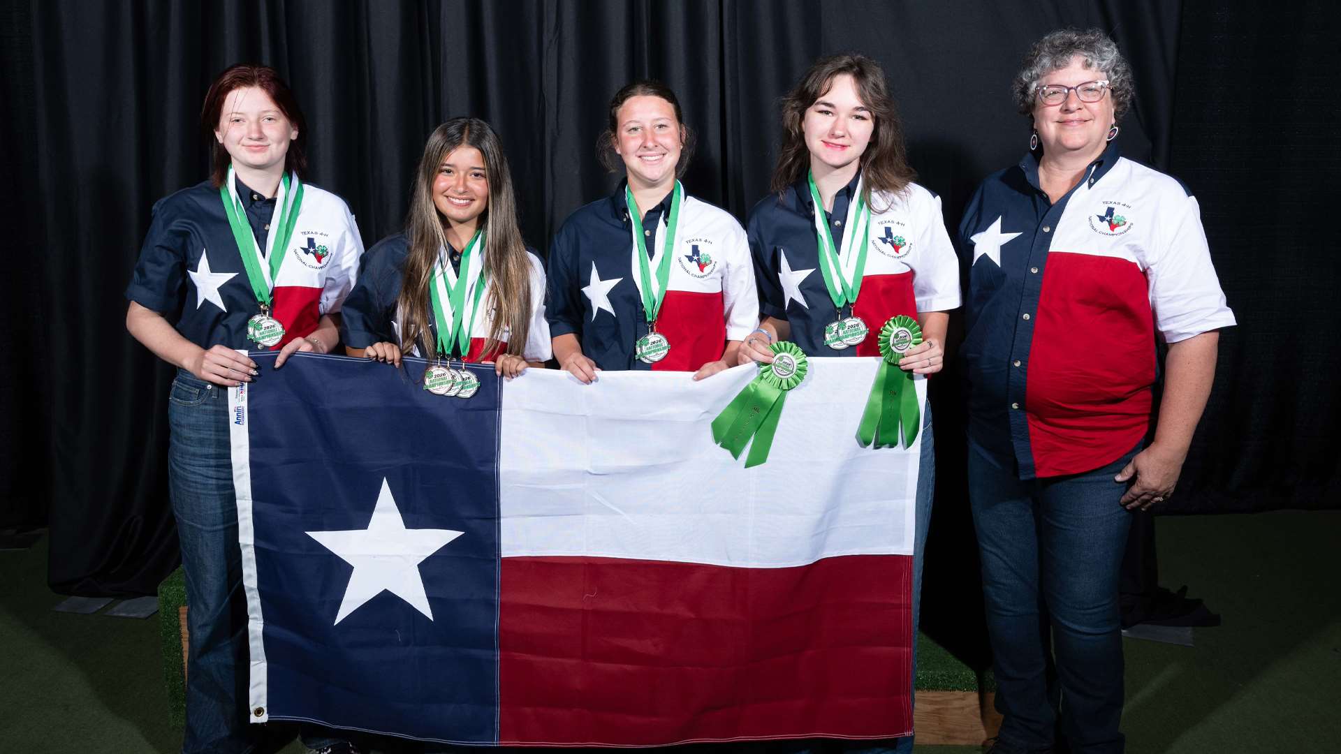 Members of the Texas 4-H shooting sports team hold their state flag while wearing medals and ribbons at the 2026 4-H Shooting Sports National Championships in Grand Island, Nebraska