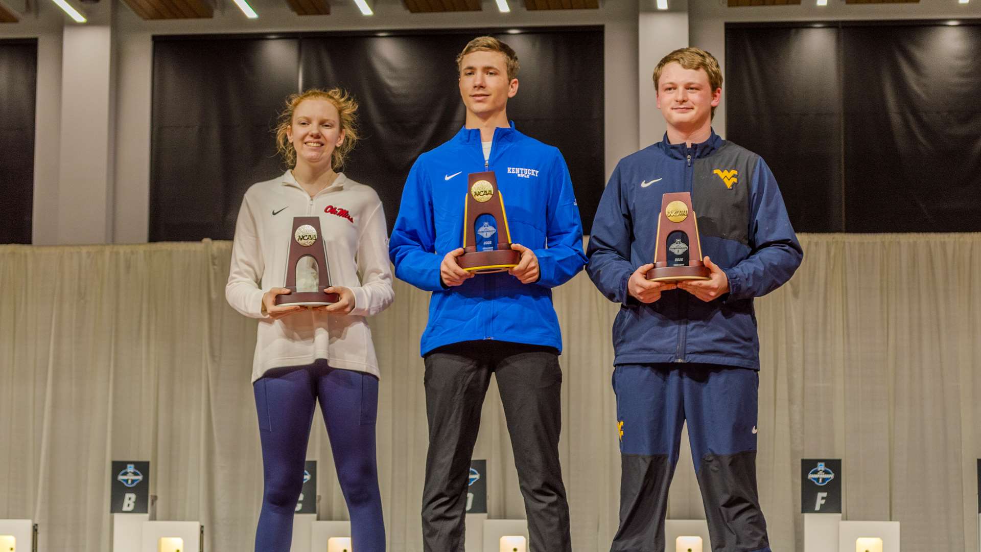 Individual smallbore podium at the 2026 NCAA Rifle Championship. Braden Peiser of Kentucky stands center as champion, flanked by the runner-up and third-place finisher